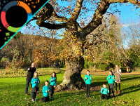 Image of teachers and pupils standing next to an oak tree