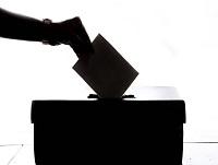 Person posting their vote in a ballot box