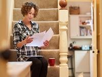A woman reading her letter from the council