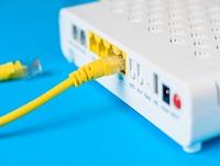 A broadband cable plugged into the back of a wifi router