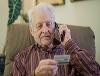 An elderly man making a credit card payment