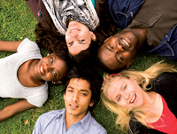Image of 5 young people lying down in a circle, smiling