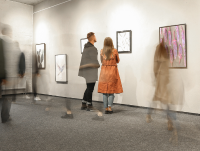 People looking at paintings at an art gallery