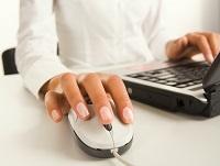 A woman using a laptop and computer mouse