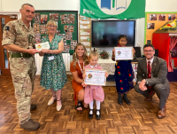 Image of pupils from Mount Street Infants School with the Armed Forces Friendly Schools Cymru Gold Status certificates