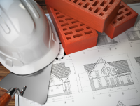 Image of a white hard helmet, red bricks and house drawings