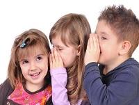 Image of three children whispering