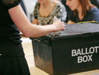 Person posting a ballot paper into a ballot box