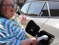 Megan, one of Compass Community Care’s clients, with her electric car, which she was supported to get through the Motability Scheme.