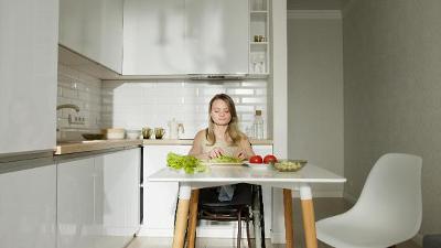 A lady in a wheelchair preparing food