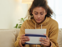 A person opening a letter