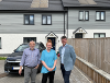 Image of three people outside a house