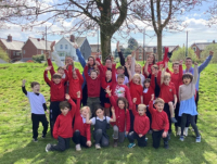 Image of pupils and staff at Ysgol Dolafon celebrating after their school as removed from Estyn’s list of schools requiring significant improvement following a positive monitoring visit.