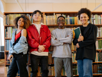 Four young people stood in a public library