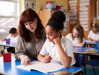 Image of a female teacher helping a learner