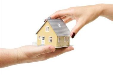 Image of hands holding a model house