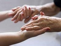 Image of younger hands holding older hands