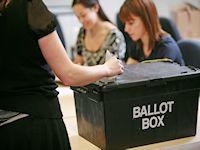 Image of a person casting their vote Image of a person casting their vote