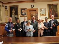 Image of a group of people receiving awards from the former Chairman of Powys County Council