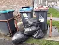 Image of fly-tipping outside flats in Ystradgynlais